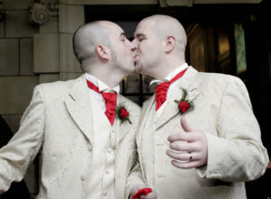 FILE- In this Monday, Dec. 19, 2005 file photo, Henry Edmont Cane, left,  and partner Christopher Patrick Flanaghan  kiss outisde Belfast, City Hall, Belfast, Northern Ireland, Monday, Dec. 19, 2005.  The couple became the first male couple to  win legal recognition for their partnership under a new  British civil partnership law.  Prime Minister David Cameron and senior British officials threw their weight behind gay marriage Tuesday, Feb. 5, 2013,  reiterating their support of a proposed bill hours ahead of a key Parliament vote on the divisive topic.  (AP Photo/Peter Morrison, File)
